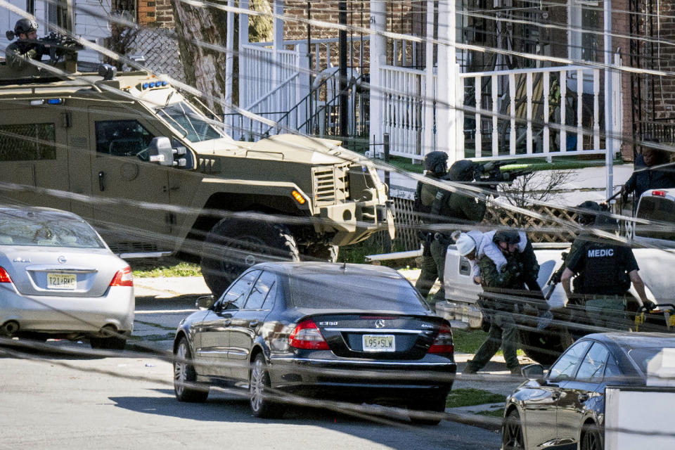 Police evacuate a person from a home. (Joe Lamberti / AFP - Getty Images)