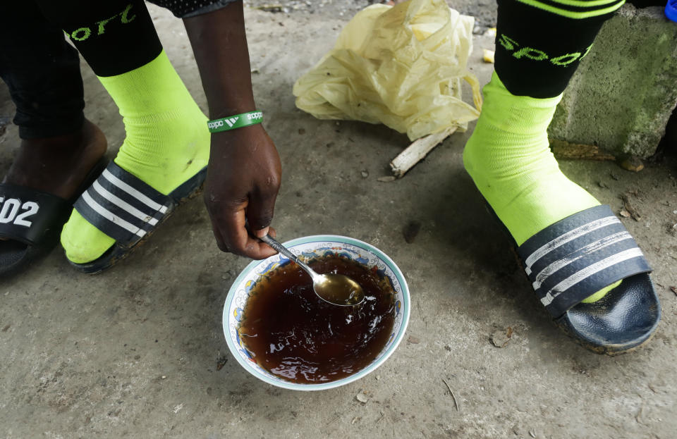 En esta imagen, tomada el 25 de mayo de 2019, un migrante de Camerún prepara un té caliente para desayunar, en Bajo Chiquito, en la provincia de Darién, en Panamá. Los migrantes se preparan pronto para partir hacia el siguiente pueblo, Peñitas, un trayecto que pueden hacer a pie bordeando los ríos Tuquesa y Chucunaque, o en barca. (AP Foto/Arnulfo Franco)