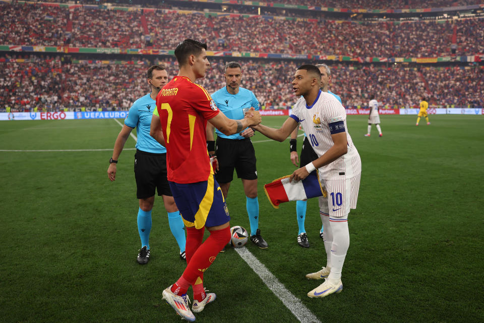 MUNICH, GERMANY - JULY 09: Alvaro Morata of Spain shakes hands with Kylian Mbappe of France as they exchange match pennants prior to the UEFA EURO 2024 Semi-Final match between Spain and France at Munich Football Arena on July 09, 2024 in Munich, Germany. (Photo by Alex Pantling - UEFA/UEFA via Getty Images)