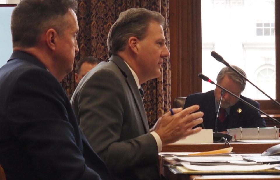 Gov. Chris Sununu (center) and his budget director, James Gerry (left), pitch the governor’s proposed budget to the House Finance Committee on Wednesday, Feb. 15, 2023.