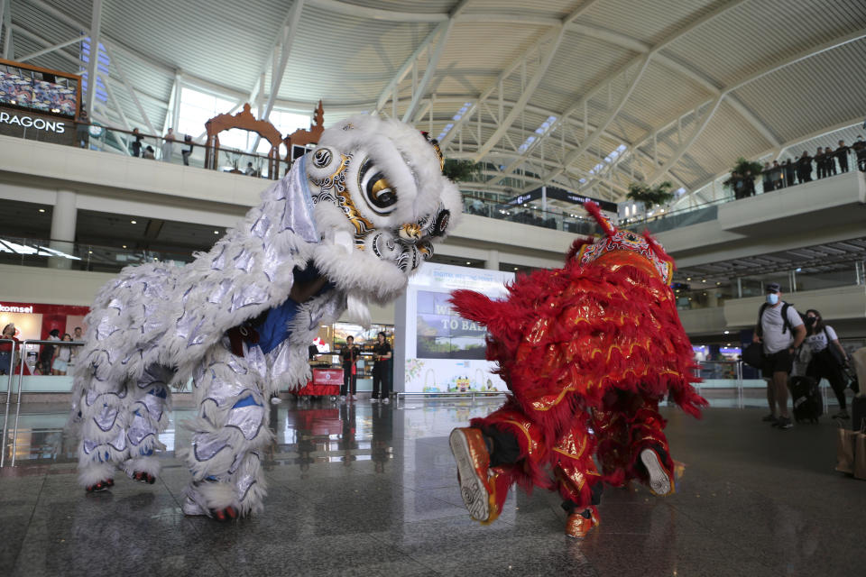 Lion dancers welcome Chinese tourists on their arrival at the Ngurah Rai international airport in Bali, Indonesia on Sunday, Jan. 22, 2023. A direct flight from China landed in Indonesia's resort island of Bali for the first time on Sunday in nearly three years after the route was cancelled due to the pandemic. At least 210 people were on board a chartered plane operated by Indonesia's Lion Air from Shenzhen in China's southern Guangdong province to Bali's international airport.(AP Photo/Firdia Lisnawati)