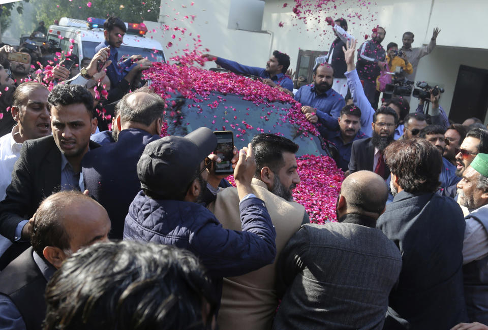 Supporters of Pakistan's ailing former prime minister Nawaz Sharif surrounds his vehicle at airport in Lahore, Pakistan, Tuesday, Nov. 19, 2019. Sharif has arrived to board a special plane after a court permitted him to leave the country for four weeks abroad for medical treatment. (AP Photo/K.M. Chaudary)