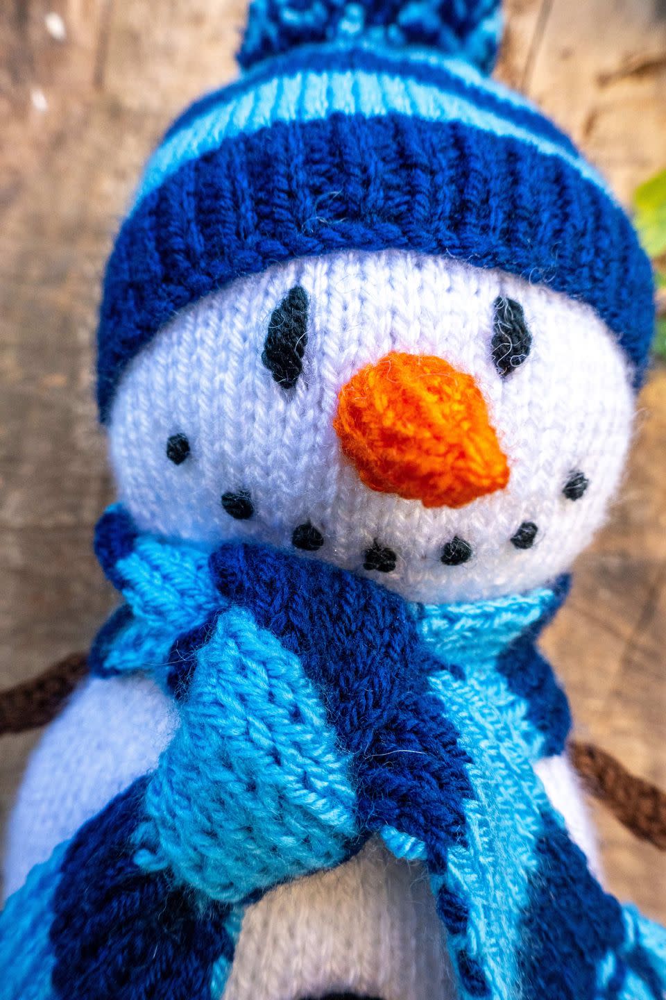 knitted snowman's carrot nose and stripy scarf