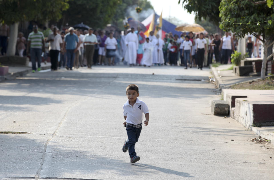 A boy runs ahead a Good Friday precession in Aracataca, the hometown of late Nobel laureate Gabriel Garcia Marquez in Colombia's Caribbean coast, Friday, April 18, 2014. (AP Photo/Ricardo Mazalan)