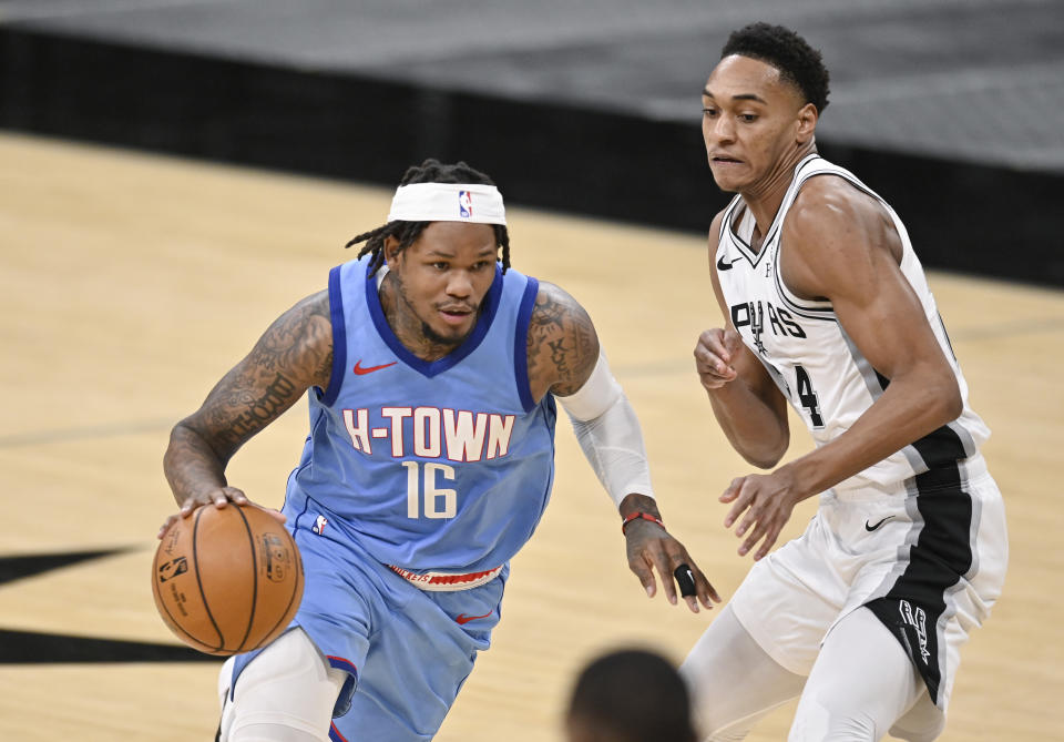 Houston Rockets' Ben McLemore (16) drives against San Antonio Spurs' Devin Vassell during the second half of an NBA basketball game, Saturday, Jan. 16, 2021, in San Antonio. (AP Photo/Darren Abate)