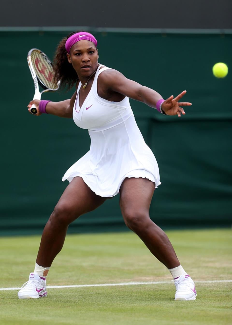 serena williams wimbledon fashion outfits and looks, LONDON, ENGLAND - JUNE 26: Serena Williams of the USA lines up a shot during her Ladies' Singles first round match against Barbora Zahlavova Strycova of Czech Republic on day two of the Wimbledon Lawn Tennis Championships at the All England Lawn Tennis and Croquet Club on June 26, 2012 in London, England. (Photo by Julian Finney/Getty Images)