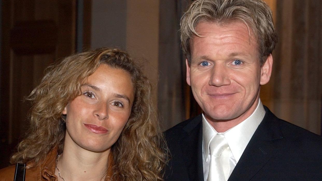 Chef Gordon Ramsay in a suit and his wife Tana in a brown leather jacket