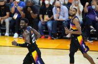 Phoenix Suns center Deandre Ayton (22) and Suns forward Mikal Bridges, right, run down the court after a Suns score against the Milwaukee Bucks during the second half of Game 1 of basketball's NBA Finals, Tuesday, July 6, 2021, in Phoenix. (AP Photo/Ross D. Franklin)