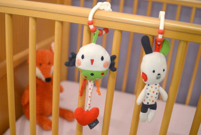 A child’s soft toys hang on the side of a cot (Anthony Devlin/PA)