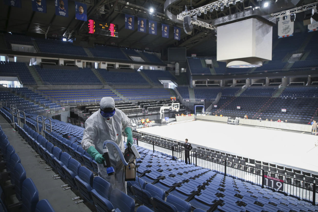 Un operario desinfecta los asientos del pabellón Sinan Erem de Estambul antes de un partido de baloncesto.