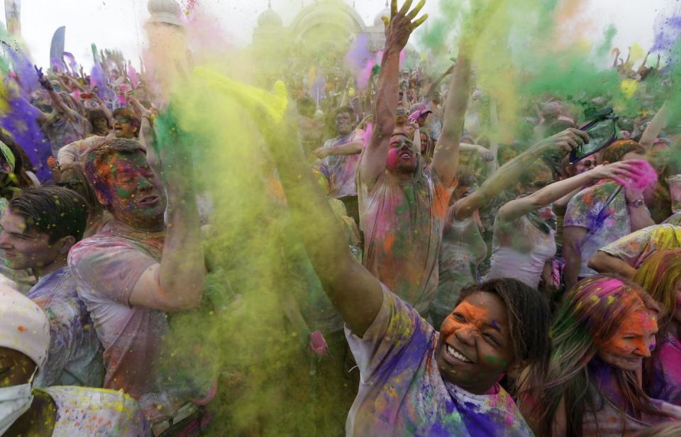Revelers throw colored corn starch in the air while celebrating during the 2014 Festival of Colors, Holi Celebration at the Krishna Temple Saturday, March 29, 2014, in Spanish Fork, Utah. Nearly 70,000 people are expected to gather starting Saturday at a Sri Sri Radha Krishna Temple in Spanish Fork for the annual two-day festival of colors. Revelers gyrate to music and partake in yoga during the all-day festival, throwing colored corn starch in the air once every hour. The Salt Lake Tribune reports that the large majority of participants are not Hindus, but Mormons. Thousands of students from nearby Brigham Young University come to take part in a festival that is drug and alcohol free. The event stems from a Hindu tradition celebrating the end of winter and the triumph of good over evil. (AP Photo/Rick Bowmer)