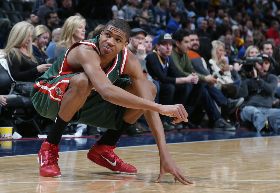Milwaukee Bucks forward Giannis Antetokounmpo, of Greece, reacts after hurting his leg against the Denver Nuggets late in the fourth quarter of the Nuggets' 110-100 victory in an NBA basketball game in Denver on Wednesday, Feb. 5, 2014. (AP Photo/David Zalubowski)