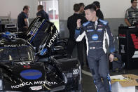 Kamui Kobayashi walks by his car in his garage before a practice session during testing for the upcoming Rolex 24 hour auto race at Daytona International Speedway, Friday, Jan. 3, 2020, in Daytona Beach, Fla. (AP Photo/John Raoux)