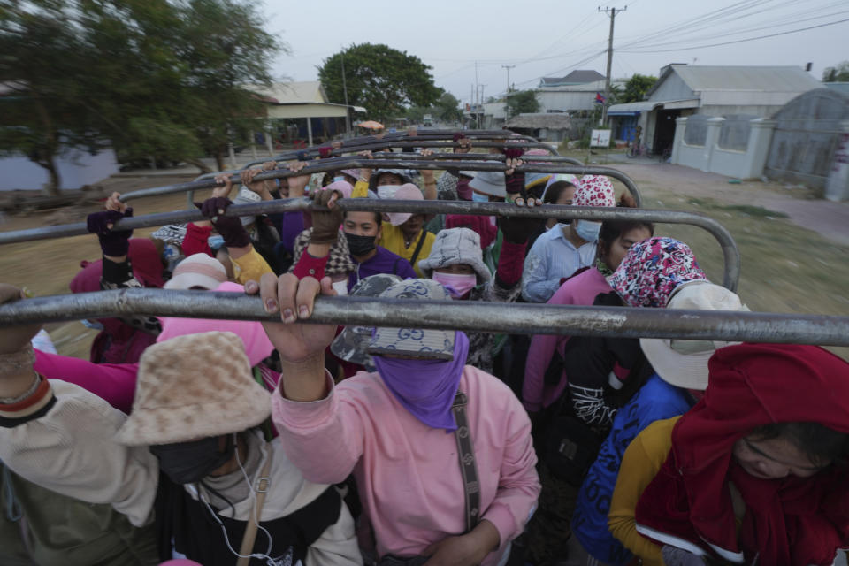 Cambodian garment workers stand on a back truck as they wear scarfs and caps to protect themselves from hot sun during return home after a day's working at garment factory outside Phnom Penh Cambodia, Monday, April 29, 2024. Southeast Asia was coping with a weeks long heat wave on Monday as record-high temperatures led to school closings in several countries and urgent health warnings throughout the region. (AP Photo/Heng Sinith)