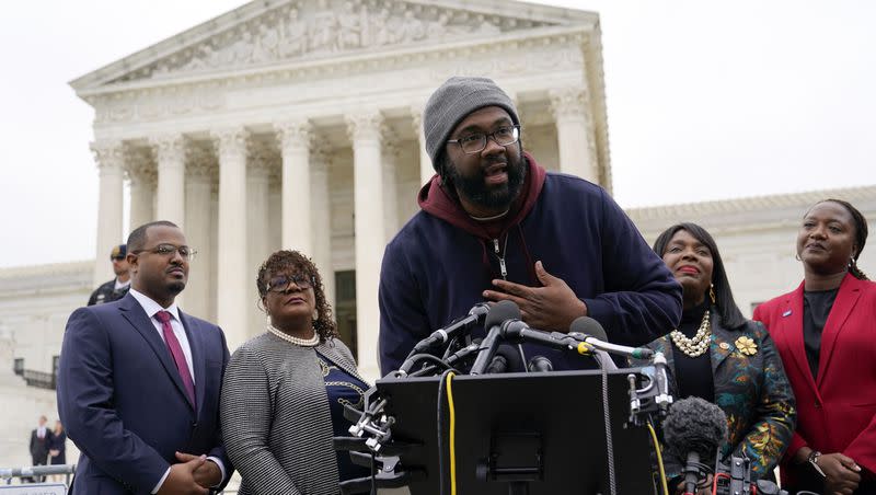 Evan Milligan, center, plaintiff in Merrill v. Milligan, an Alabama redistricting case that could have far-reaching effects on minority voting power across the United States, speaks with reporters following oral arguments at the Supreme Court in Washington, Oct. 4, 2022.