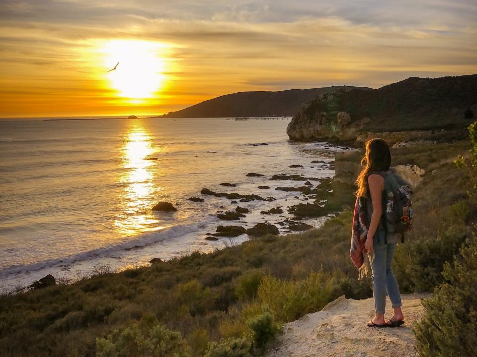 Emily looks out at the sunset on a California beach.