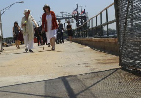 Rosalee Grable, (L) walks off the ferry to Hart's Island with Melinda Hunt in New York July 19, 2015. REUTERS/Sebastien Malo