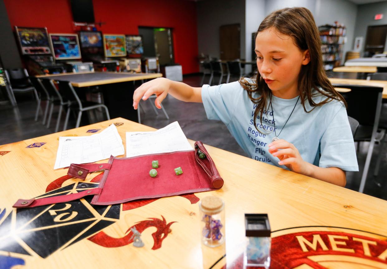 Violet Black shows her dice and leather dice mat at Meta-Games Unlimited on Monday, July 3, 2023.