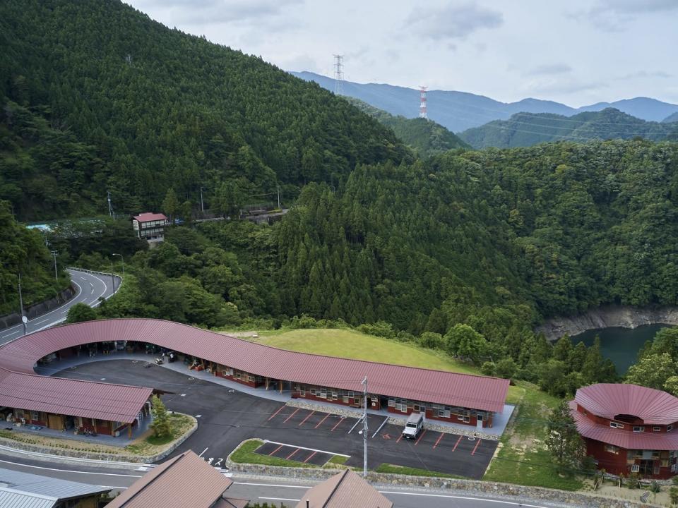 An aerial view of the exterior of the center on a cloudy day with mountains in the background