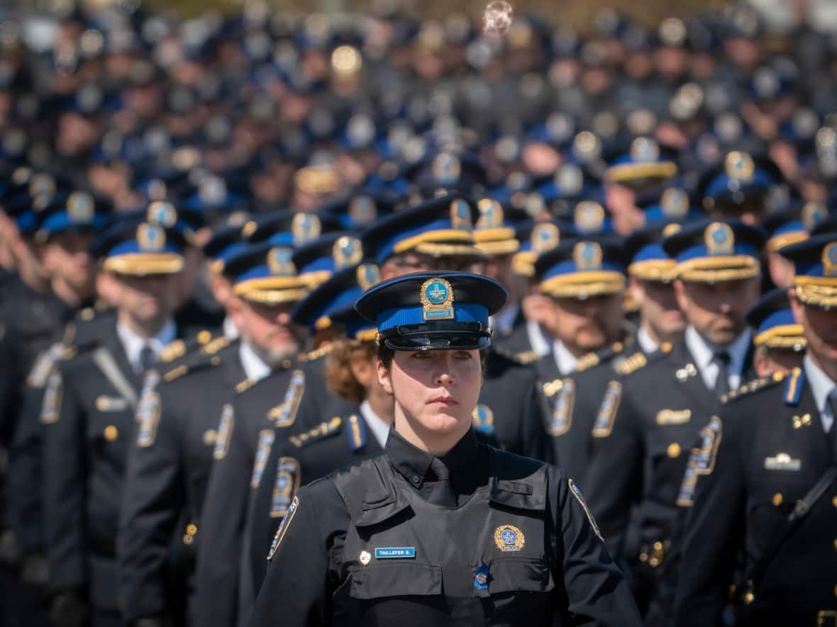 Montreal police officers take part in the funeral cortège for their Sûreté du Québec colleague, Sgt. Maureen Breau, killed last month during an arrest in Louiseville, Que. (Ivanoh Demers/CBC - image credit)