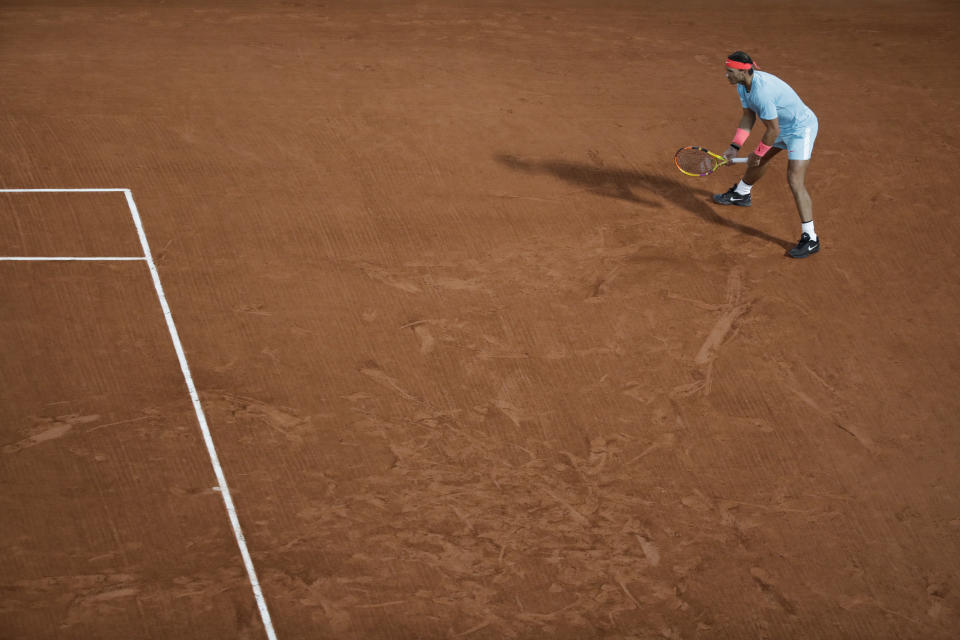 Spain's Rafael Nadal waits for Italy's Stefano Travaglia's serve, in his usual position far from the baseline in the third round match of the French Open tennis tournament at the Roland Garros stadium in Paris, France, Friday, Oct. 2, 2020. Nadal's position leaves him vulnerable to underarm serves, used by some players at this year's French Open, including by the man Nadal beat in the second round. There is some discussion about whether such serves are a legitimate tactic and Nadal thinks they are fine as long as they are used to try to win a point and not to show disrespect to an opponent. (AP Photo/Alessandra Tarantino)