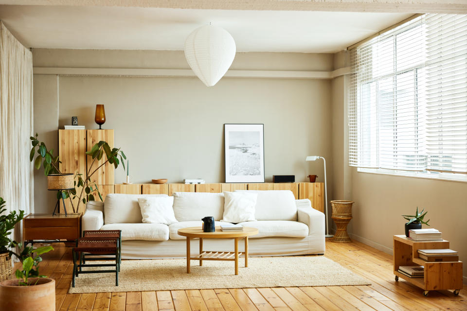 linen chest, linen chest spring sale, Sofa with coffee table by window in living room. Picture frame is on cabinet at home. Interior of modern bright apartment.