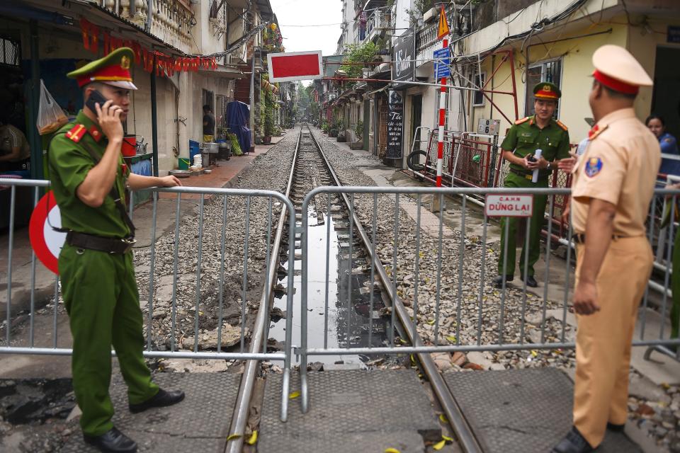 Police personnel stand guard next to a barricade on Hanoi's popular train street on October 10, 2019 following a municipal authorities order to deal with cafes and "ensure safety" on the railway track. (Photo by Nhac NGUYEN / AFP) (Photo by NHAC NGUYEN/AFP via Getty Images)