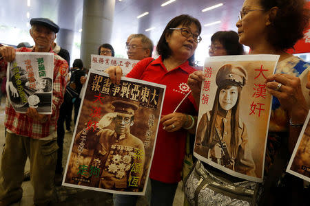 Protesters hold printouts depicting legislator-elect Yau Wai-ching (R) and Baggio Leung (C) as traitors during a demonstration outside the Legislative Council in Hong Kong, China October 19, 2016. REUTERS/Bobby Yip