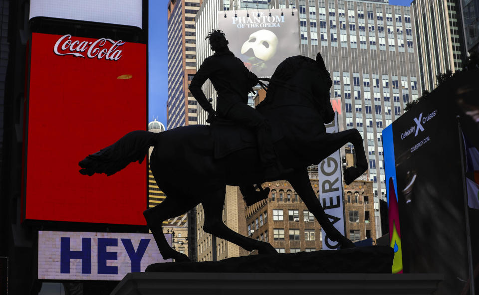 A bronze sculpture, "Rumors of War," by artist Kehinde Wiley, appears in Times Square at an unveiling on Friday Sept. 27, 2019, in New York. The work, depicting of a young African American in urban streetwear sitting astride a galloping horse, will be exhibited through December 1. (AP Photo/Bebeto Matthews)