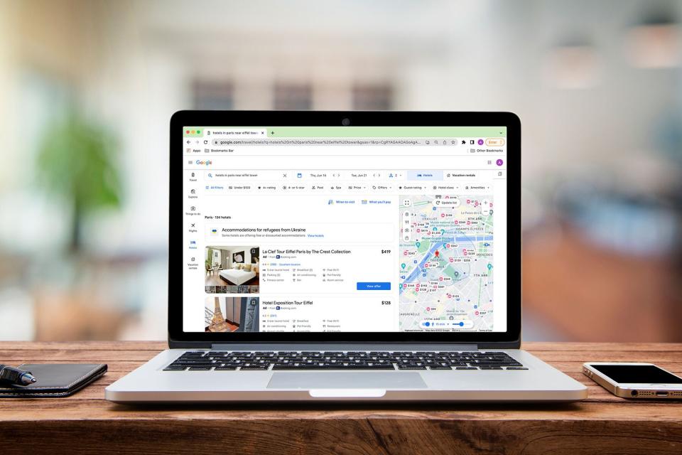 A laptop open to the GoogleTravel interface looking for hotels in paris