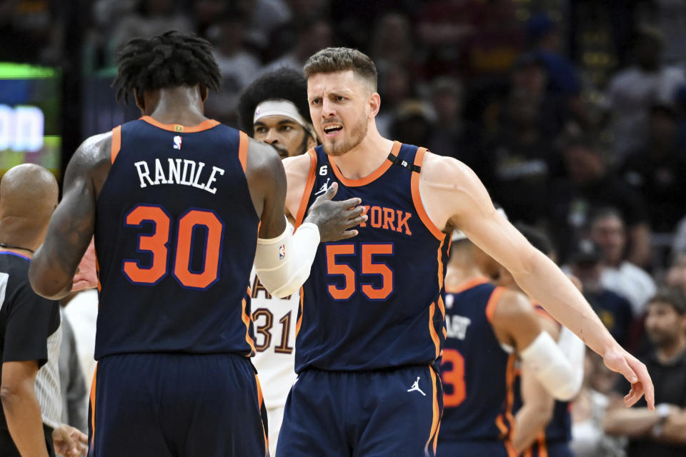 New York Knicks' Isaiah Hartenstein (55) and Julius Randle (30) celebrate the team's 101-97 win over the Cleveland Cavaliers in Game 1 in a first-round NBA basketball playoffs series Saturday, April 15, 2023, in Cleveland. (AP Photo/Nick Cammett)