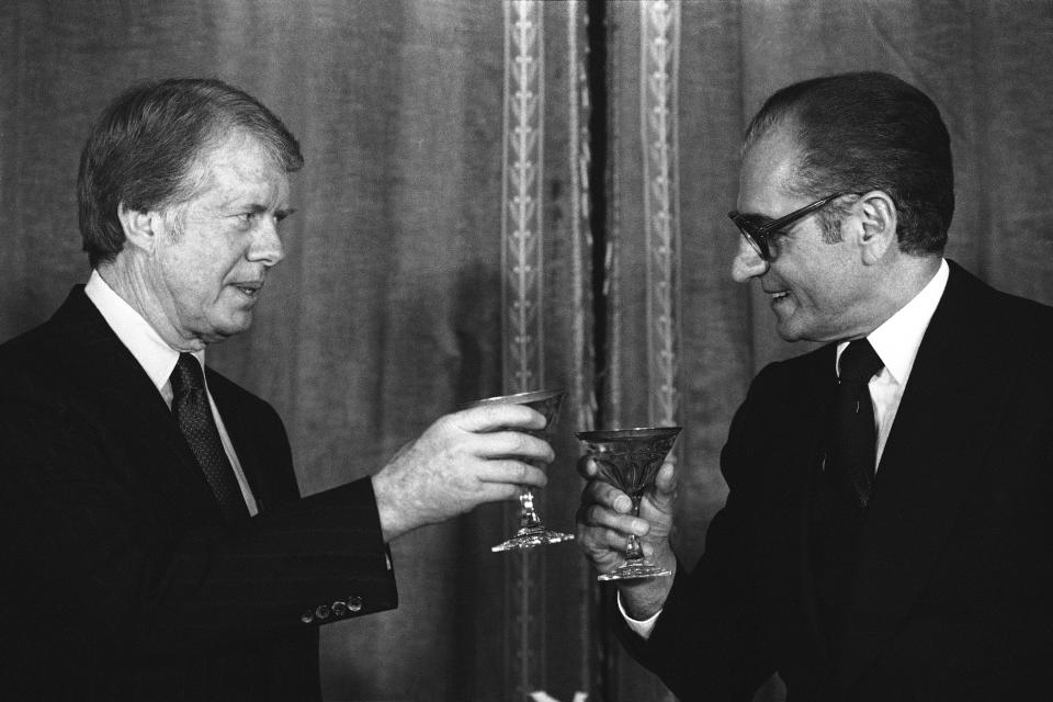 FILE - In this Dec. 31, 1977 file photograph, President Jimmy Carter toasts Shah Mohammad Reza Pahlavi of Iran during a New Year's Eve dinner at Niavaran Palace in Tehran, Iran. The fall of the Peacock Throne and the rise of the Islamic Revolution in Iran grew out of the shah’s ever-tightening control over the country as other Middle East monarchies toppled. (AP Photo, File)