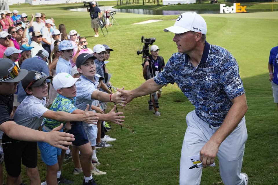 Jordan Spieth slaps hands with young spectators as he walks off the 18th hole after finishing the third round of the FedEx St. Jude Championship golf tournament Saturday, Aug. 12, 2023, in Memphis, Tenn. (AP Photo/George Walker IV)