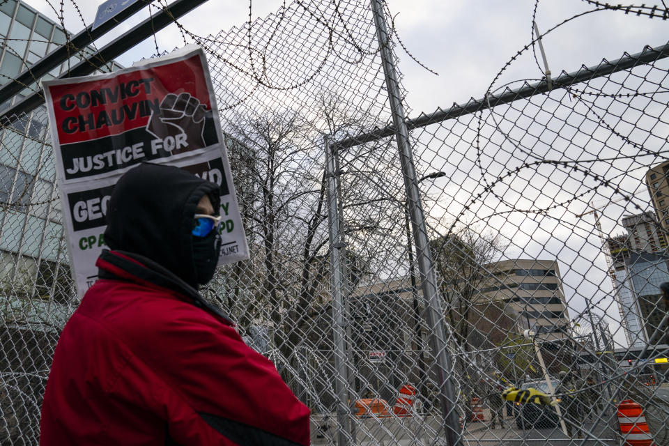 Demonstrators rally outside the Minneapolis 3rd Precinct guarded by perimeter security fences and razor wire as the murder trial against the former Minneapolis police officer Derek Chauvin in the killing of George Floyd advances to jury deliberations, Monday, April 19, 2021, in Minneapolis. (AP Photo/John Minchillo)