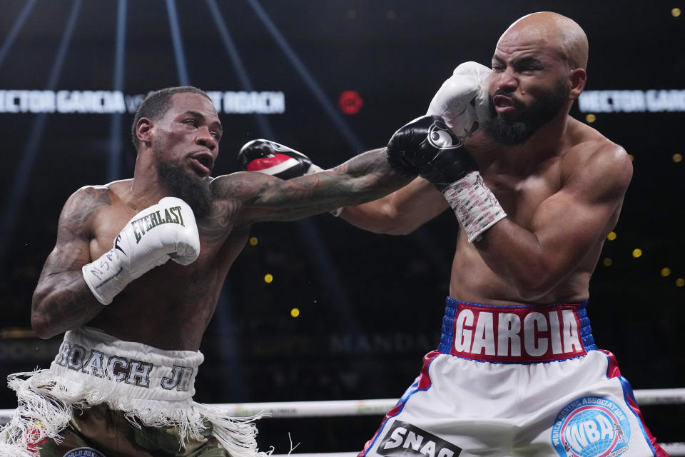 Lamont Roach, left, hits Hector Garcia, right, in a super featherweight championship boxing match Saturday, Nov. 25, 2023, in Las Vegas. (AP Photo/John Locher)