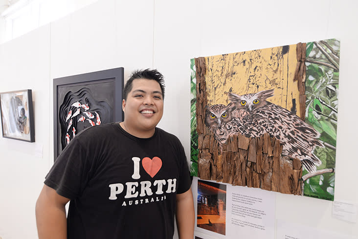 Nasir Nadsir with his artwork which features wood chopped into pieces to become a 'tree' for the owls.