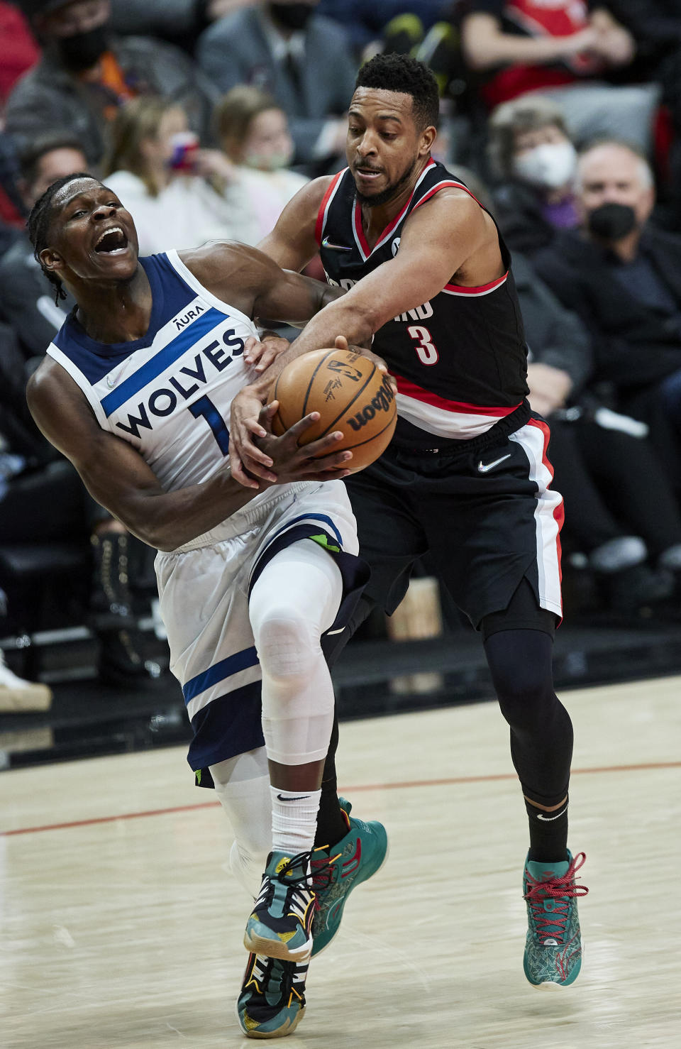 Minnesota Timberwolves forward Anthony Edwards, left, is fouled by Portland Trail Blazers guard CJ McCollum during the first half of an NBA basketball game in Portland, Ore., Tuesday, Jan. 25, 2022. (AP Photo/Craig Mitchelldyer)