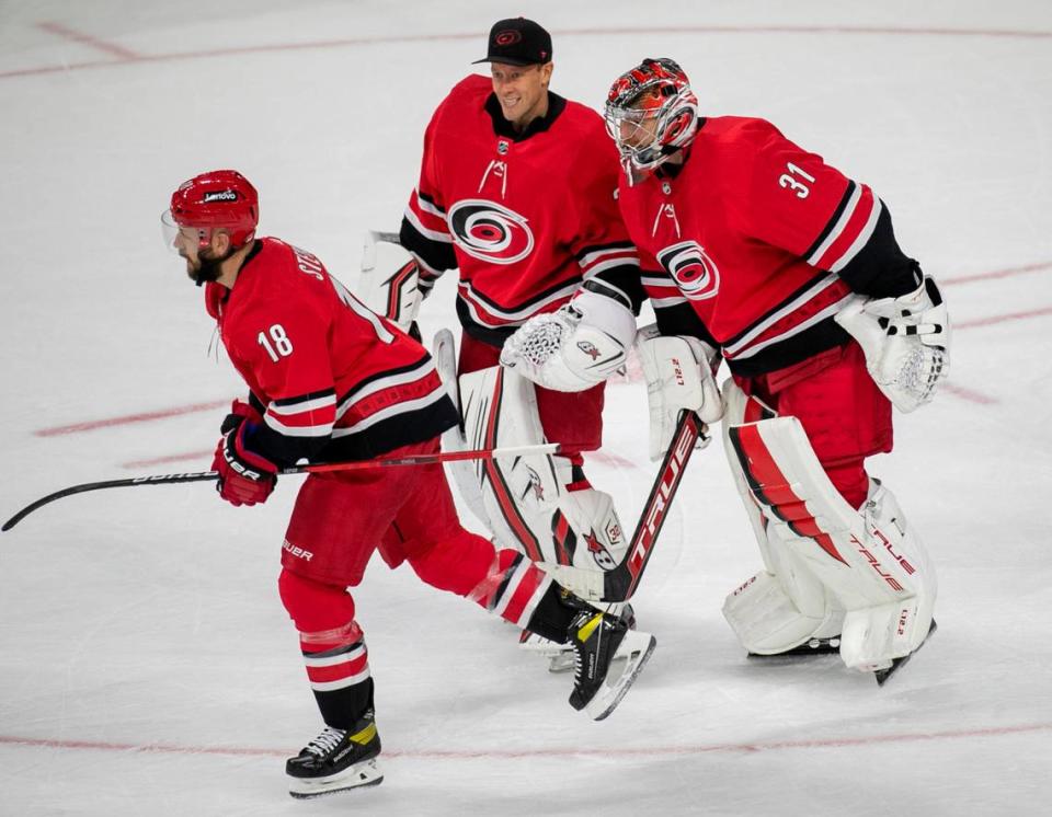 Carolina Hurricanes winning goalie Frederik Andersen (31) skates with Antii Raanta (32) as they celebrate their 6-3 victory over the New York Islanders on Thursday, October 14, 2021 at PNC Arena in Raleigh, N.C.