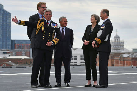Britain's Prime Minister Theresa May talks with Commodore Jerry Kyd, Captain of the British aircraft carrier HMS Queen Elizabeth, during her tour of the ship, after it arrived at Portsmouth Naval base, its new home port, in Portsmouth, Britain August 16, 2017. REUTERS/Ben Stansall