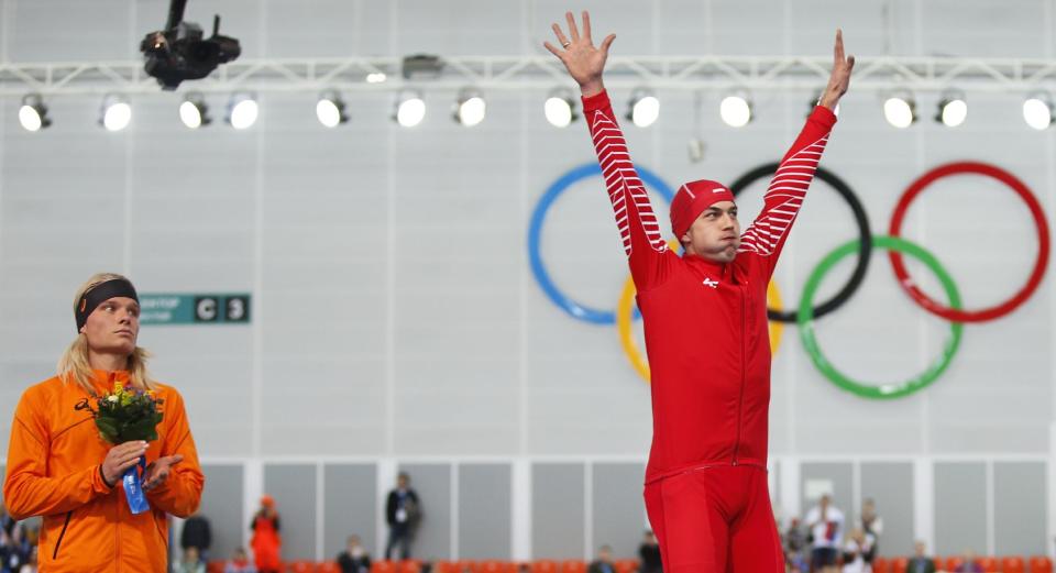 Gold medallist Poland's Zbigniew Brodka, right, acknowledges the crowd as silver medallist Koen Verweij of the Netherlands stands beside him during the flower ceremony for the men's 1,500-meter speedskating race at the Adler Arena Skating Center during the 2014 Winter Olympics in Sochi, Russia, Saturday, Feb. 15, 2014. Verweij lost the gold medal by three thousandth of a second. (AP Photo/Pavel Golovkin)