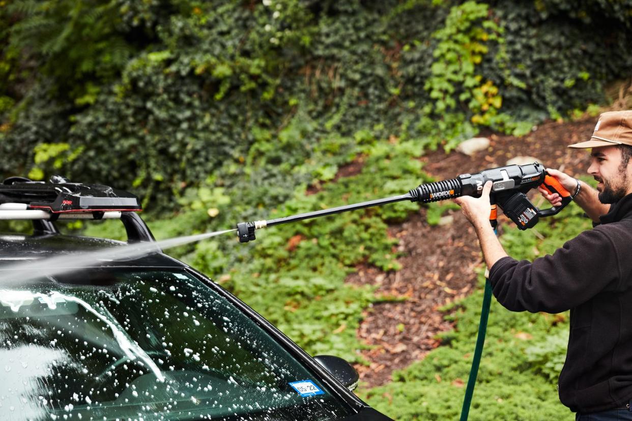 a person cleaning their car with a pressure washer