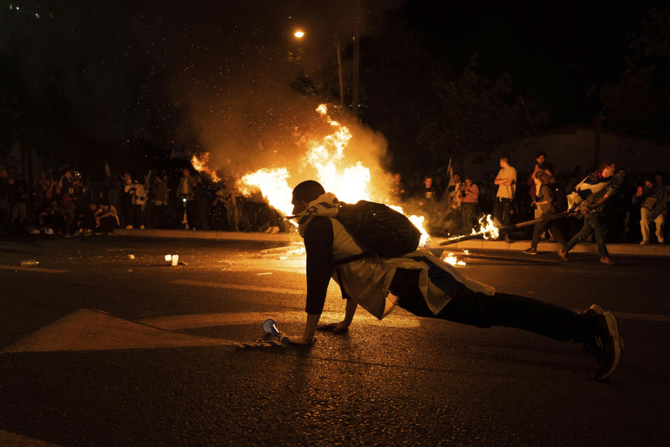 Anti government demonstrators block streets and clash with police during a protest against plans by Prime Minister Benjamin Netanyahu's government to overhaul the judicial system, in Tel Aviv, Israel, Monday, March 27, 2023. Netanyahu has delayed his contentious judicial overhaul plan after a wave of mass protests. The Israeli leader said said he wanted "to avoid civil war" by making time to seek a compromise with political opponents. (AP Photo/Oded Balilty)