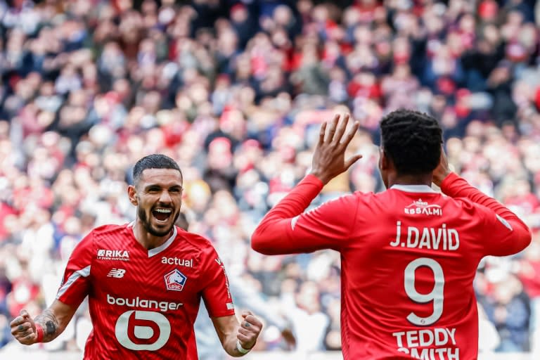 Le Canadien du Lille Jonathan David (de dos), buteur contre Strasbourg, remercie son passeur Rémy Cabella, le 21 avril 2024 à Villeneuve-d'Ascq (Sameer Al-DOUMY)