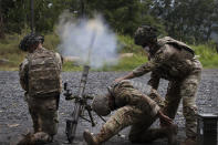 Cadets learn to fire mortars, Friday, Aug. 7, 2020, at the U.S. Military Academy in West Point, N.Y. The pandemic is not stopping summer training. Cadets had to wear masks this year for much of the training. (AP Photo/Mark Lennihan)