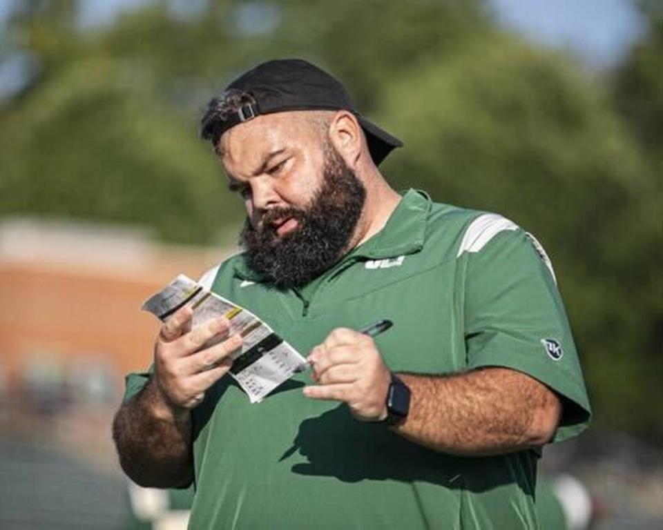 Charlotte football defensive coordinator Ryan Osborn checks his play sheet during practice last season.