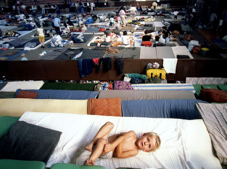 FILE PHOTO: A young Serbian refugee from the Krajina region rests in a sports complex which houses about 2.000 people, August 12, 1995. REUTERS/Yannis Behrakis/File photo