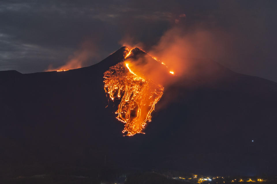 Lava flows from the Mt Etna volcano, near Catania in Sicily, southern Italy, early Tuesday, Feb. 23 , 2021. The explosion started before midnight on Monday night, provoking a huge eruption plume that rose for several kilometers from the top of Etna, as reported by The National Institute of Geophysics and Volcanology, Etneo Observatory. (AP Photo/Salvatore Allegra)