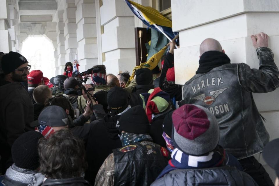 FILE – Insurrectionists loyal to President Donald Trump try to open a door of the U.S. Capitol as they riot in Washington, Jan. 6, 2021. (AP Photo/Jose Luis Magana, File)