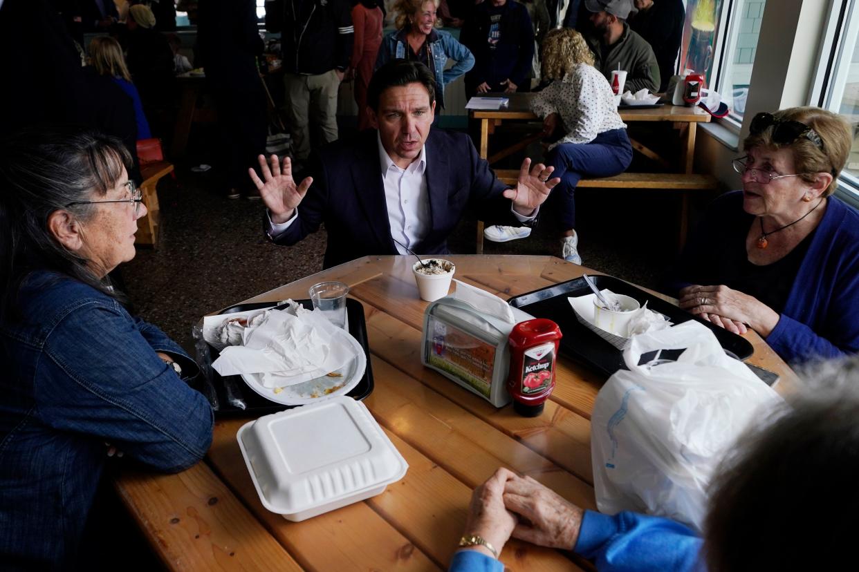 Republican presidential candidate, Florida Gov. Ron DeSantis, talks Oct. 24 with patrons during a campaign stop at a restaurant in Epping, N.H.