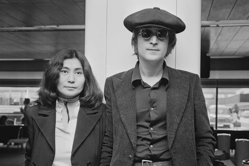 <p>R. Brigden/Daily Express/Getty</p> Yoko Ono and John Lennon pose for an image at London Airport in 1971